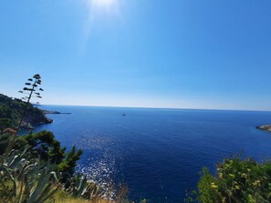 A coastal landscape with a clear sky, a boat on the water, and vegetation. - Gästezimmer "Meerblick" mit Blick auf das Wasser by Interhome (Dubrovnik)