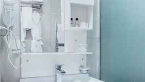 A modern bathroom with a white sink, a mirror, and a glass shower enclosure. - Citrus Boutique Hotel (Baku)
