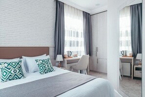 A hotel room with a bed, a desk, and a chair. - Citrus Boutique Hotel (Baku)