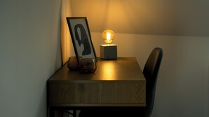 A wooden table with a framed picture, a glass, and a lit bulb on a stand. - Moderne City Zimmer mit eigenem Bad (Bamberg)