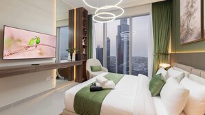 Una habitación de hotel moderna con una cama grande, televisión, vista a la ciudad y una pared verde decorativa.