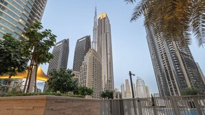 Un horizonte urbano moderno con rascacielos, entre ellos una torre destacada con un diseño singular.