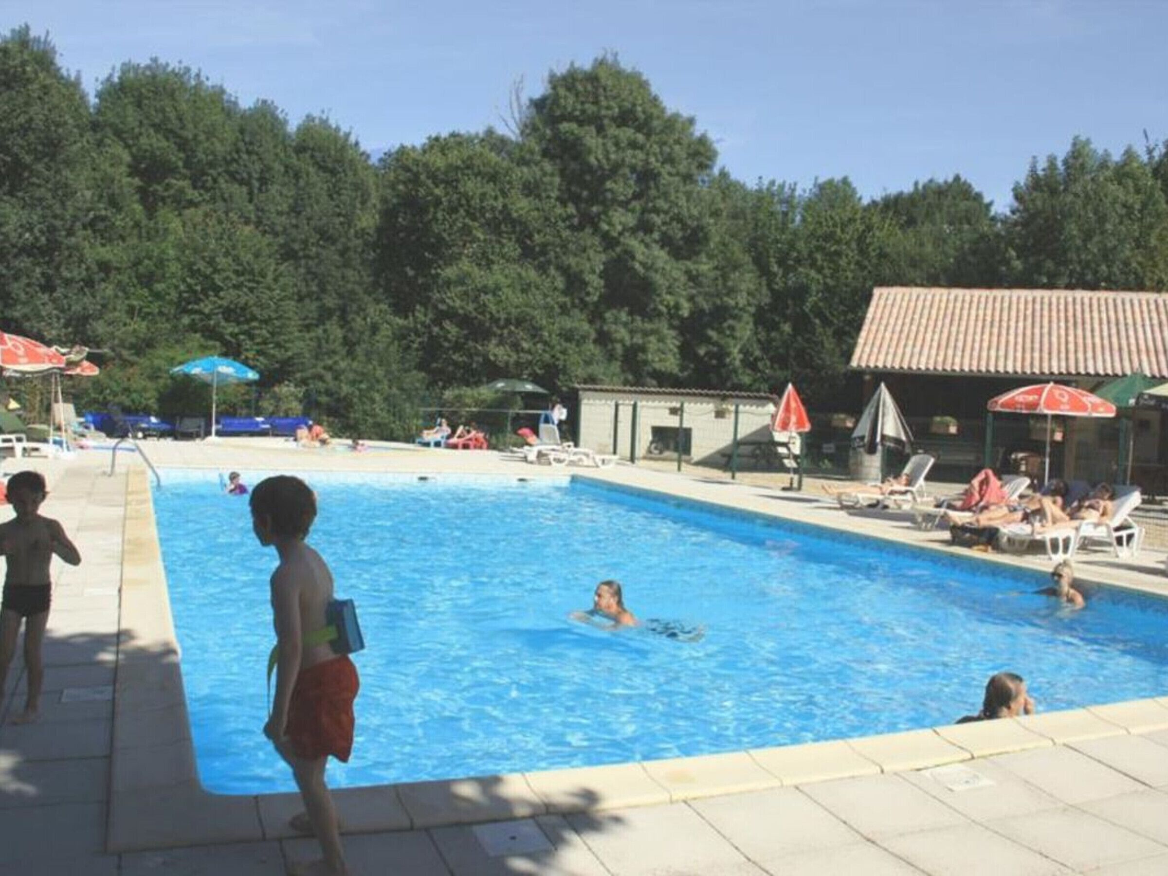 Ein Schwimmbad mit darin schwimmenden und liegenden Personen.