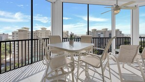 Ein Balkon mit Tisch und Stühlen, großen Fenstern und einem Deckenventilator.