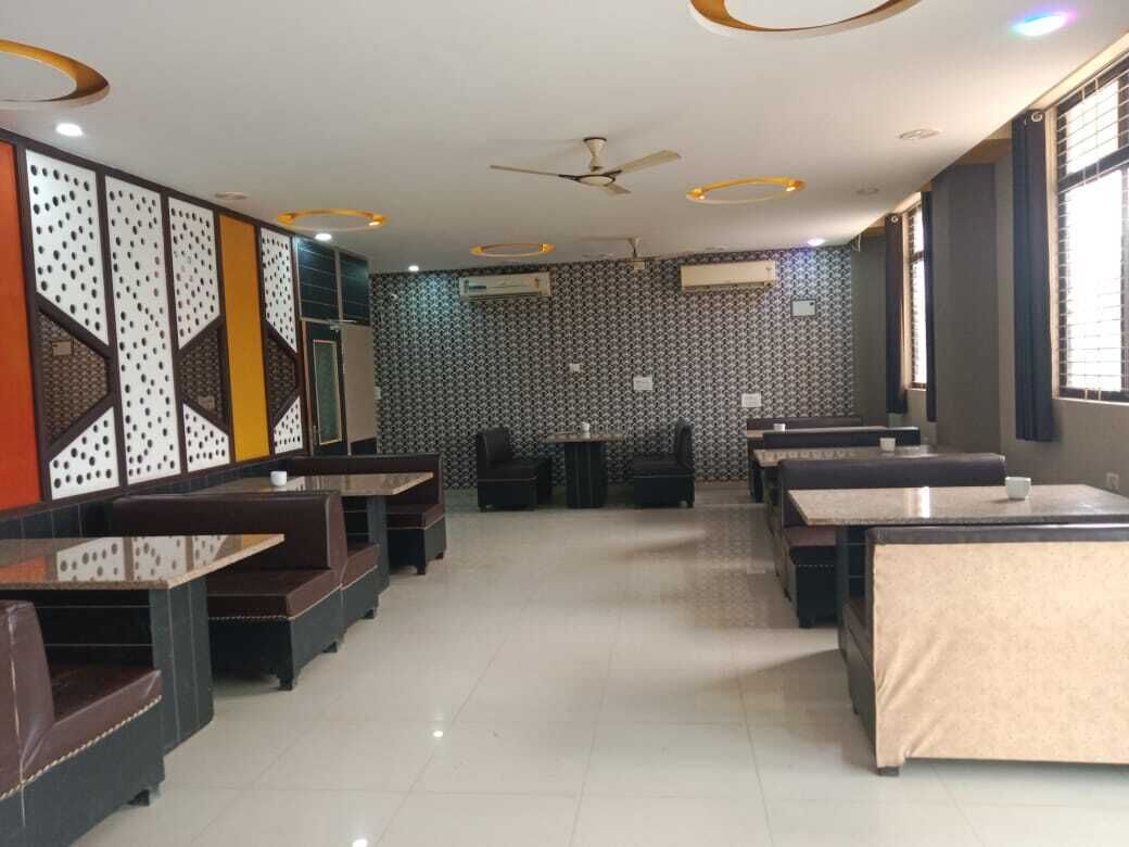 A restaurant with booths and tables, ceiling fans, and patterned walls.