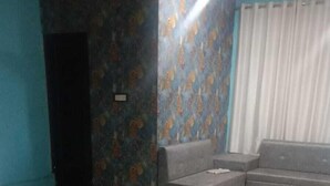 Un dormitorio con cama, sofá y pared con diseño.
