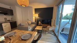 A modern living space with a dining area, sofa, TV, and a balcony with a view. - Two-room apartment in Sète - Terrace, Parking, WiFi (Sète)