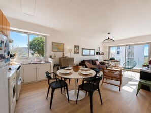 Una cocina moderna con comedor, sofá y balcón con vistas.