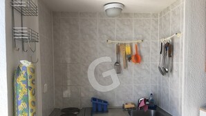 A compact kitchen with a gas stove, sink, and hanging utensils. - Cozy studio downtown near the beach (La Tranche-sur-Mer)