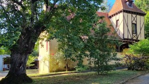 Un edificio tradicional con techo a dos aguas y una estructura adosada más pequeña con tejado de tejas.
