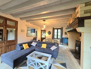 A spacious living area with a large sofa, a coffee table, and a fireplace. - Renovated family home with large garden and pets allowed (Saint-Crépin-et-Carlucet)