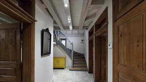 Un pasillo con puertas de madera, una escalera y un armario amarillo.