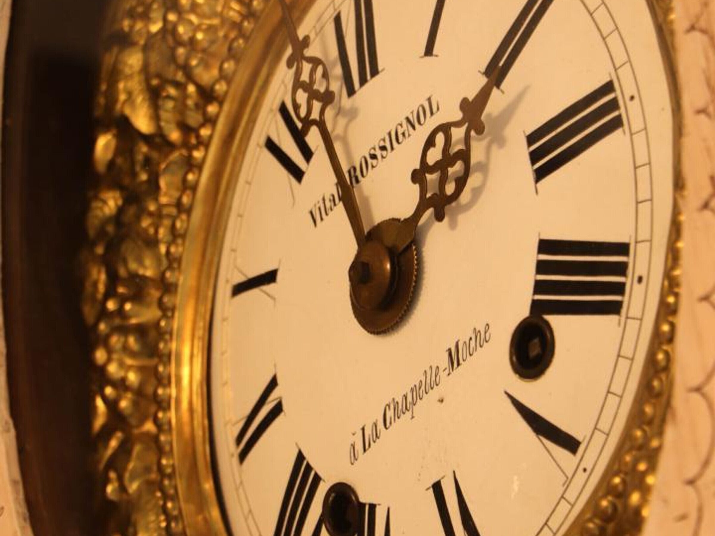 Un primo piano del quadrante di un orologio con numeri romani e le scritte "VITAL RUSSIAN" e "La Chapelle-Mache" visibili.