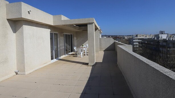 A rooftop terrace with a table and chairs, a view of the city, and a clear sky. - Beautiful One-Bedroom Penthouse with Spectacular Terrace in Central Salou (Salou)