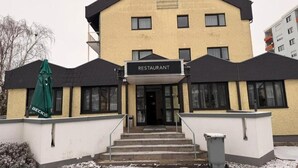 A two-story building with a sign reading "RESTAURANT" at the entrance. - Roomie Hotel (Schriesheim)