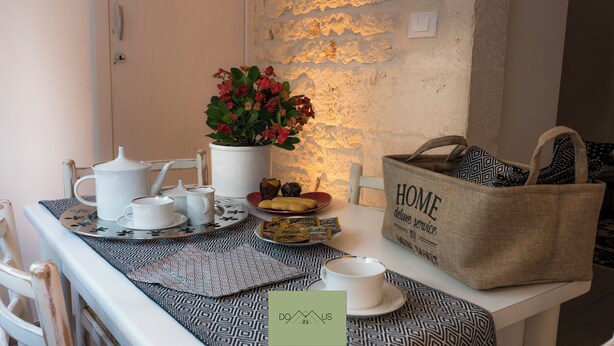 Une table dressée avec un service à thé, un panier et un arrangement floral.