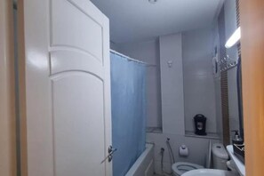 Regadera, secadora de cabello, toallas, papel de baño 