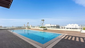 A rooftop swimming pool with a clear view of the cityscape in the background. - Stayshort - 1 Bed in JGC Sleeps 4 With Balcony (Dubai)