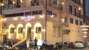 Ein mehrstöckiges Hotel mit Balkonen, einer Treppe und einem Schild mit der Aufschrift 'Hotel Umesh'.