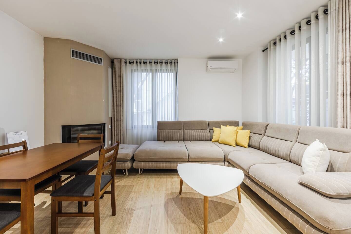 A living room with a sofa, a coffee table, and a dining table with chairs.