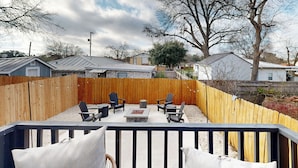A backyard with a wooden deck, outdoor seating area, and a stone fire pit. - 2 BR Home one Block From Botanical Gardens (San Antonio)