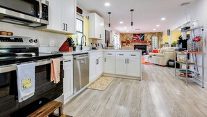 A modern kitchen with white cabinets, stainless steel appliances, and a wooden floor. - 10 Mi to Public Beaches: Port St Lucie Getaway (Port Saint Lucie)