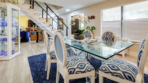 A modern dining area with a glass table, patterned chairs, and a staircase leading to another level. - 10 Mi to Public Beaches: Port St Lucie Getaway (Port Saint Lucie)