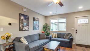 A living room with two grey sofas, a wooden coffee table, and a ceiling fan. - Denver Home w/ Patio Near City Park & Cherry Creek (Denver)