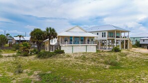 A beachfront house with a covered porch, a separate garage, and a second-story balcony. - ENJOY THE WONDERFUL natural daylight in this comfortable home (St. George Island)