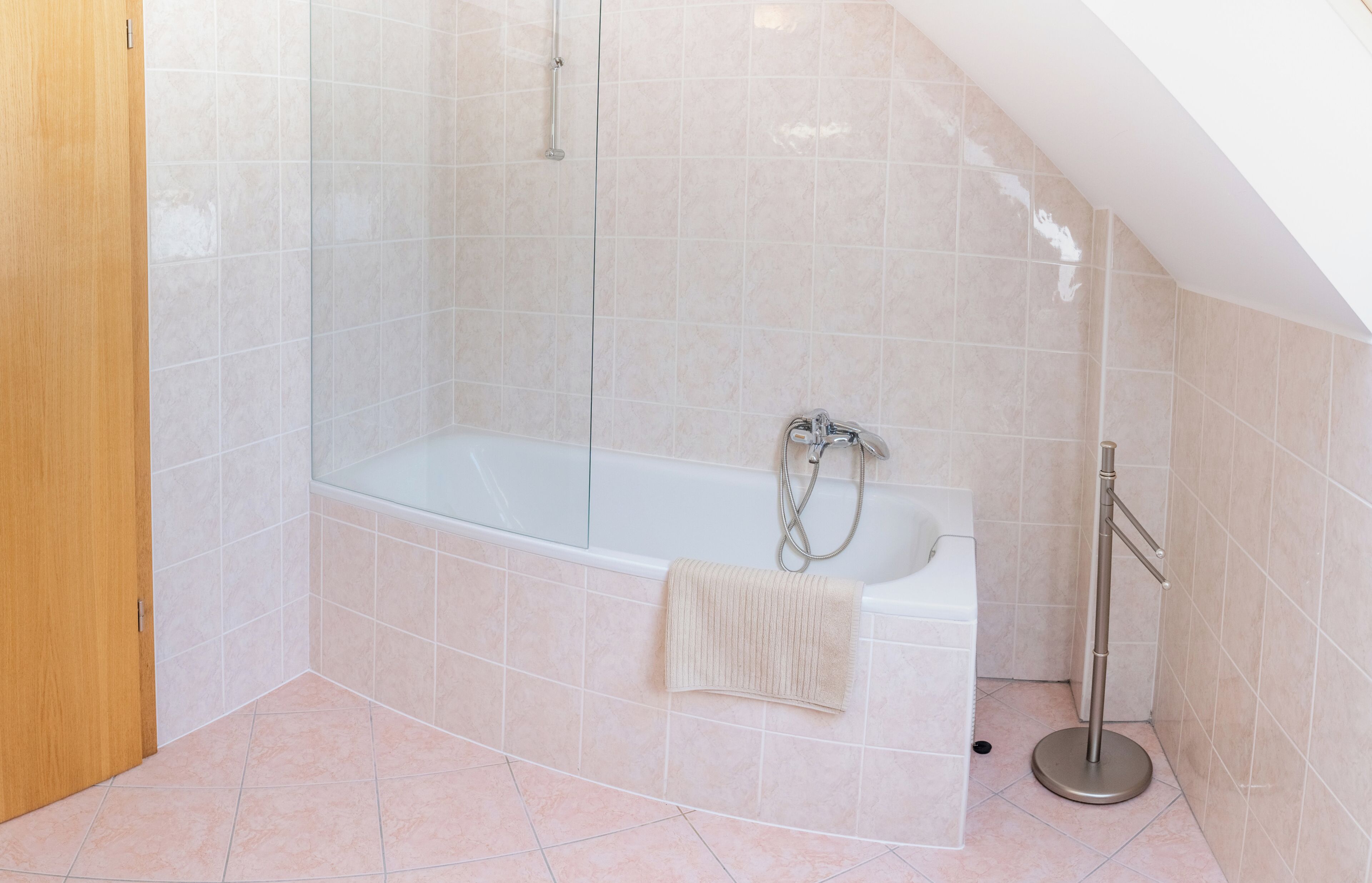 Une salle de bain moderne avec une baignoire sur pieds, une douche à parois de verre et un porte-serviettes.