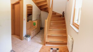 A wooden staircase leading to a second floor, a small storage unit with drawers, and a radiator on the wall. - House Parabola – 4-Bedroom Mountain Retreat with Breathtaking Views, Sleeps 10 (Log pod Mangartom)