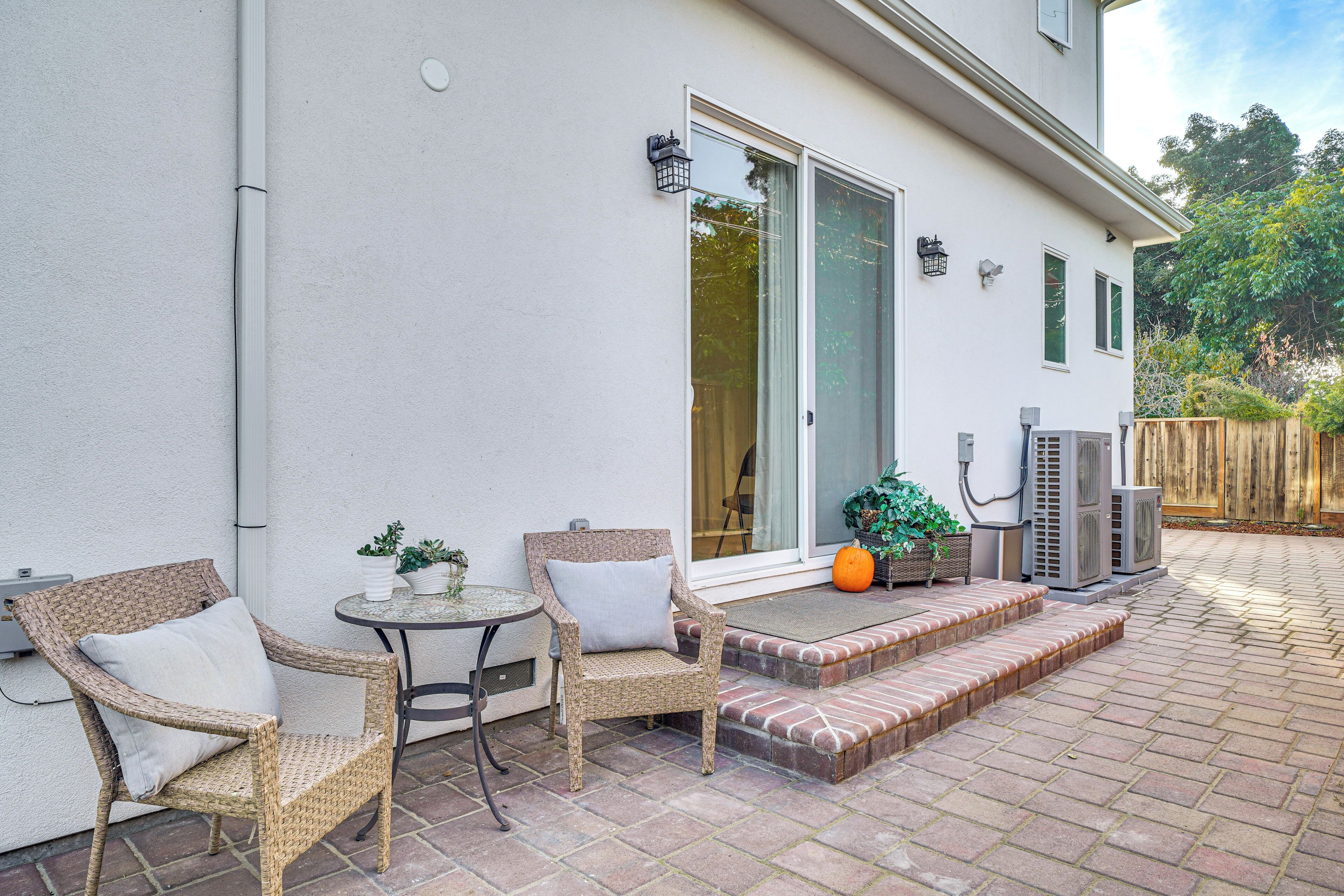 A patio with wicker chairs, a small table, and a potted plant.