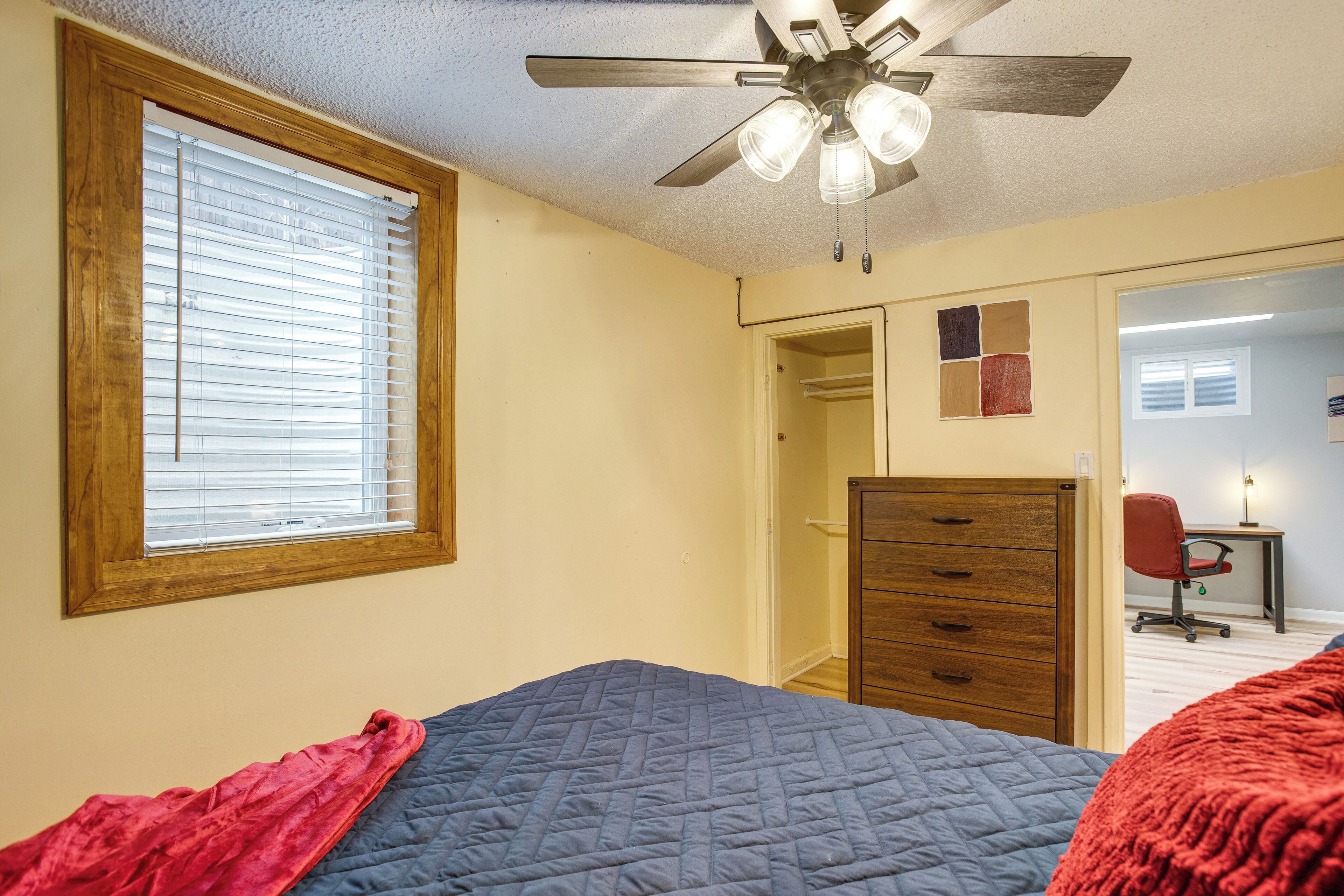 A bedroom with a bed, a dresser, a desk, and a chair.