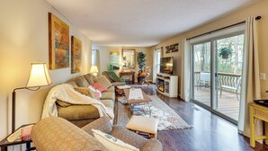 A cozy living room with a sofa, a coffee table, and a fireplace. There is a sliding glass door leading to an outdoor deck. - Near Lakes & Trails! Cozy Hot Springs Hideaway (Hot Springs Village)