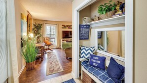 A cozy living room with a wooden floor, a sofa with blue cushions, and a bookshelf with decorative items. - Near Lakes & Trails! Cozy Hot Springs Hideaway (Hot Springs Village)