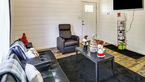 A living room with a sofa, a chair, a coffee table, and a TV mounted on the wall. - 1 Mi to Dtwn Enterprise: Pet-friendly Home w/ Yard (Enterprise)