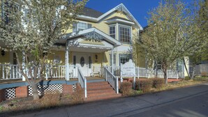 A two-story building with a porch, a signboard, and a staircase leading to the entrance. - New Listing! Rosewood Studio at Dusty Rose Inn | Main Street Creede (Creede)