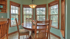 A dining area with a wooden table, chairs, and a chandelier. - New Listing! Roseview Loft at Dusty Rose Inn | Main Street Creede | (Creede)