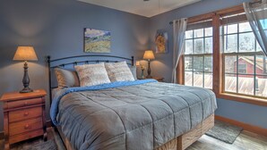 A bedroom with a bed, two bedside tables, a ceiling fan, and a window with curtains. - New Listing! Roseview Loft at Dusty Rose Inn | Main Street Creede | (Creede)