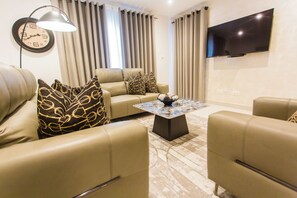 Departamento de lujo, 1 habitación, balcón | Área de sala de estar | Smart TV de 55 pulgadas con canales vía satélite y Netflix 