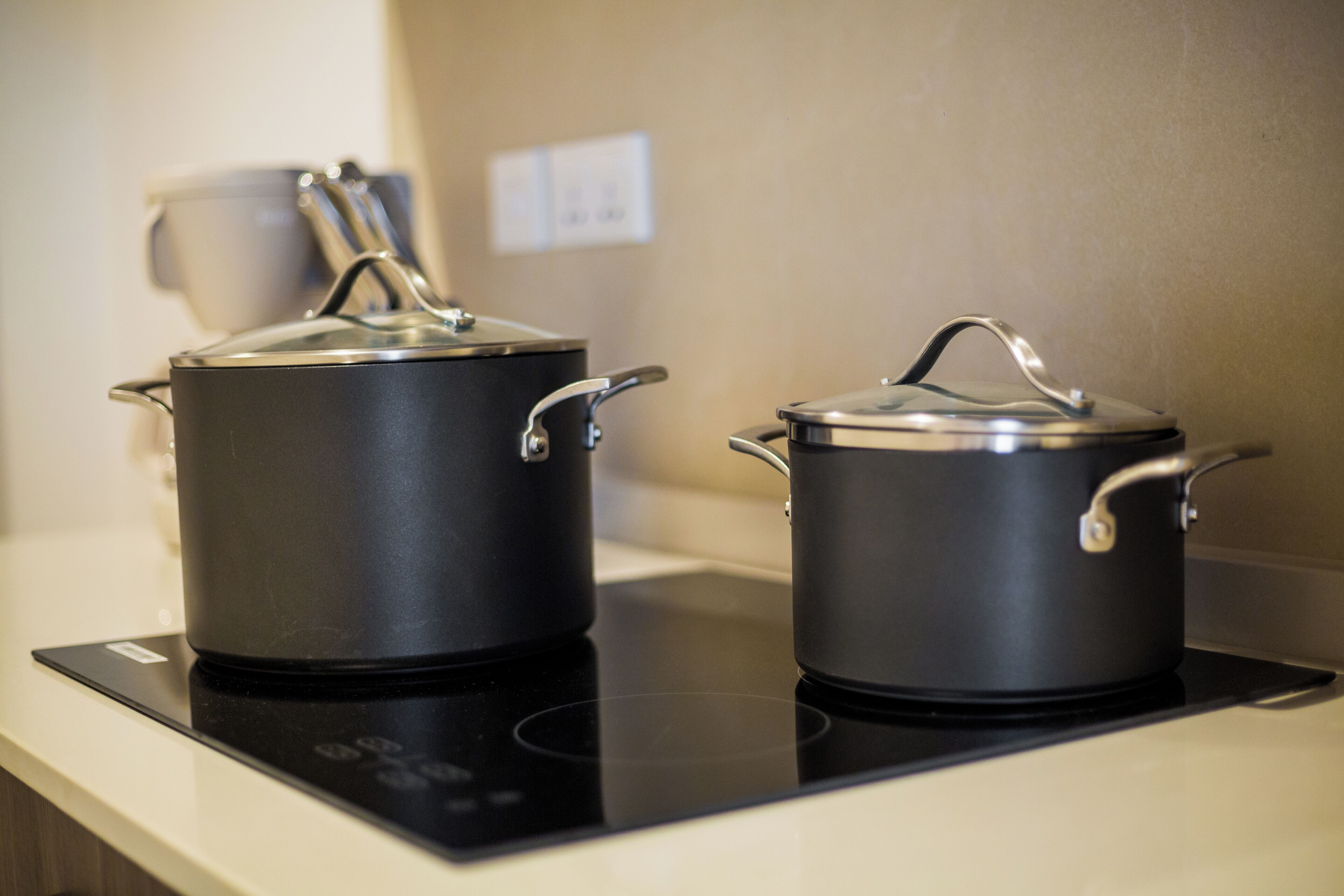 Two black pots on an induction cooktop.