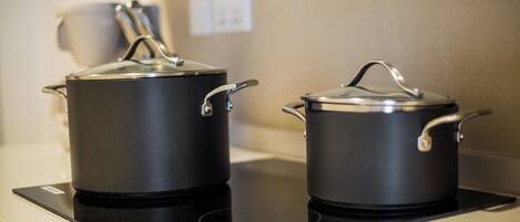 Two black pots on an induction cooktop.