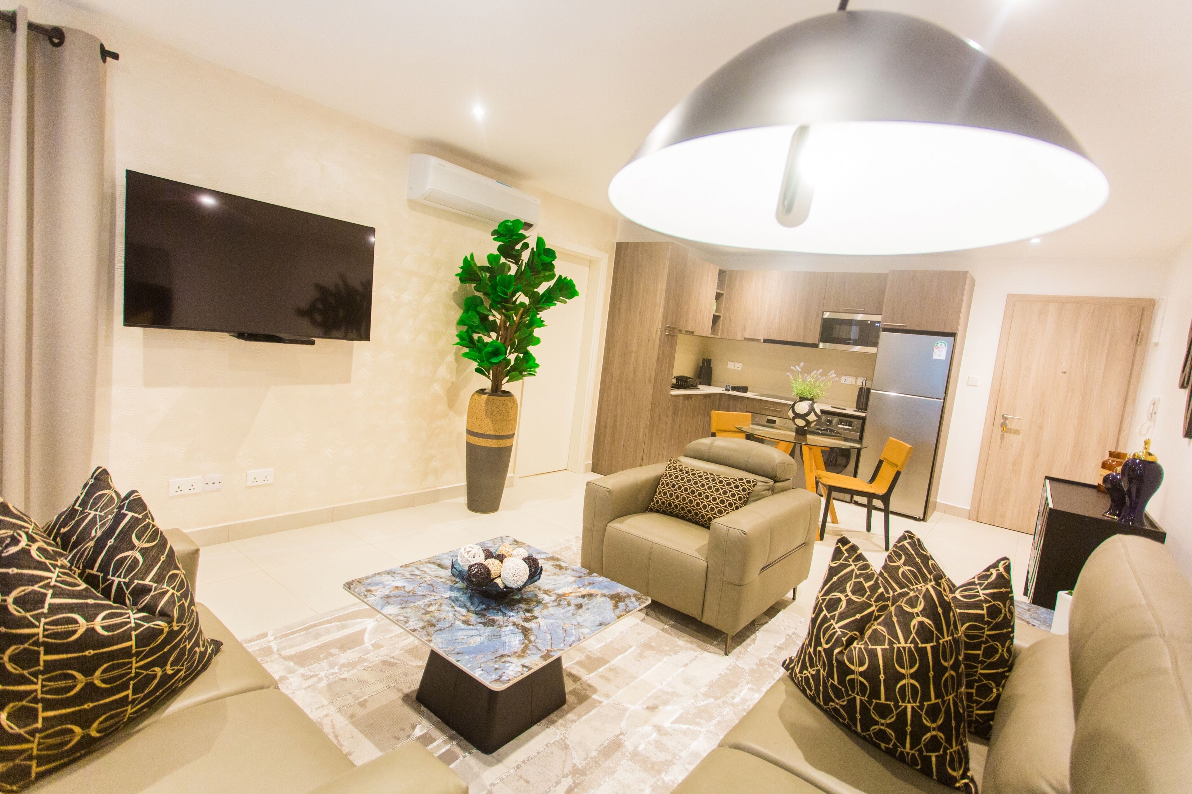 Un salon moderne avec un canapé, une table basse et un téléviseur fixé au mur.