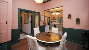 Une salle à manger avec une table ronde, des chaises et un lustre.
