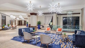 A spacious lobby with modern furniture, a large window with a view, and decorative lighting. - Close to Disney World + Pools. Spa. Restaurants. (Orlando)