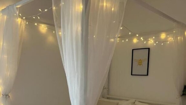 A bedroom with a canopy bed, bedside tables, and a framed picture on the wall. - The Cotton Mill Hideaway (Manchester)