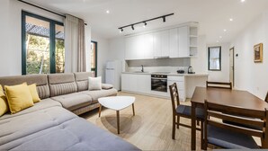 Uma sala de estar moderna com sofá, mesa de centro e mesa de jantar.