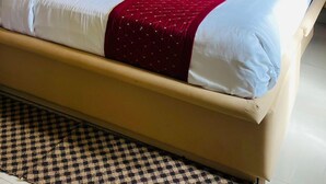 Una habitación de hotel con una cama, ventilador de techo, aire acondicionado y una ventana con cortinas.