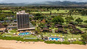 Un resort con un edificio grande, un área de piscina y una playa.
