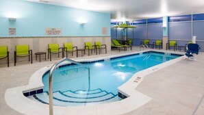 An indoor swimming pool with a tiled edge, surrounded by green chairs and a blue wall with a 'No Lifeguard on Duty' sign. - Near Downtown Parker | Free Breakfast + Pool (Parker)
